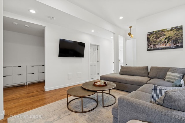 living room featuring baseboards, wood finished floors, and recessed lighting