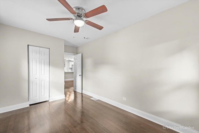 unfurnished bedroom featuring dark wood-type flooring, ceiling fan, and a closet