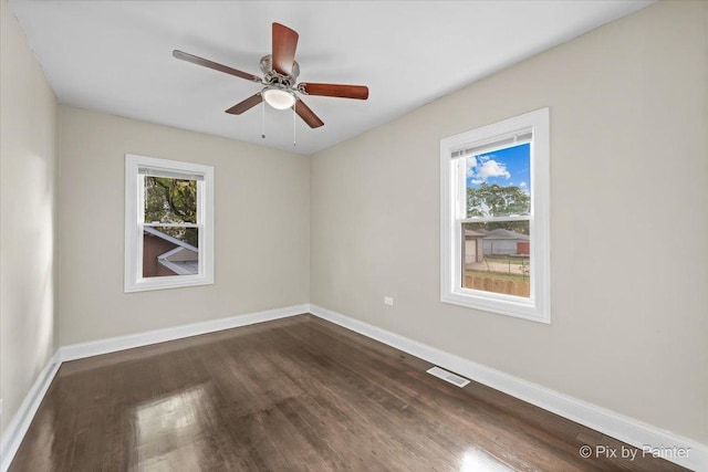 spare room featuring ceiling fan, plenty of natural light, and dark hardwood / wood-style flooring