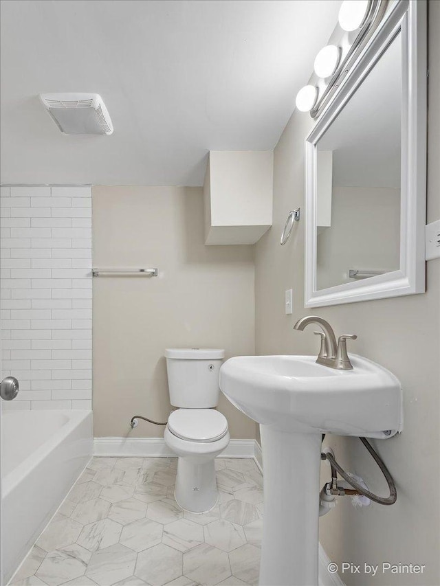 bathroom with tiled shower / bath and toilet