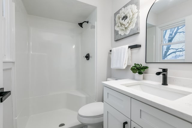 bathroom featuring walk in shower, vanity, and toilet