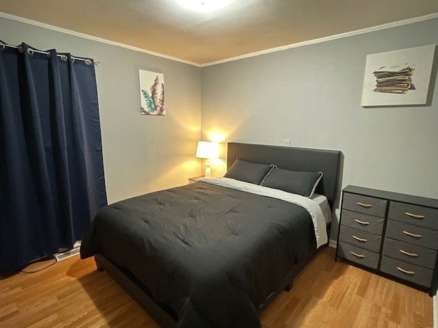 bedroom featuring ornamental molding and light hardwood / wood-style floors