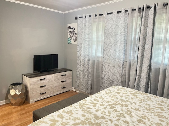 bedroom featuring crown molding and wood-type flooring