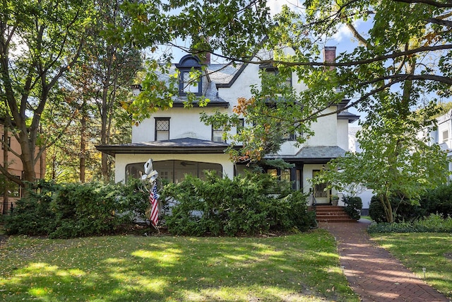 view of front of home featuring a sunroom and a front yard