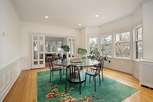 dining space featuring radiator, plenty of natural light, and light wood-type flooring