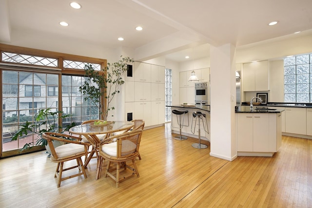 dining room with sink and light wood-type flooring