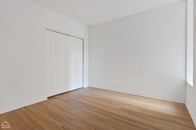 unfurnished bedroom featuring a closet and light wood-type flooring