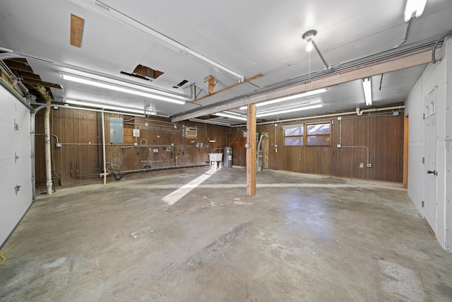 garage with sink, electric panel, and wood walls