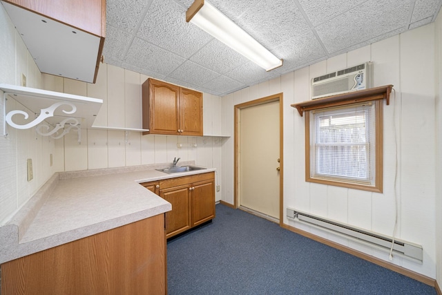 kitchen with dark colored carpet, an AC wall unit, a baseboard heating unit, and sink