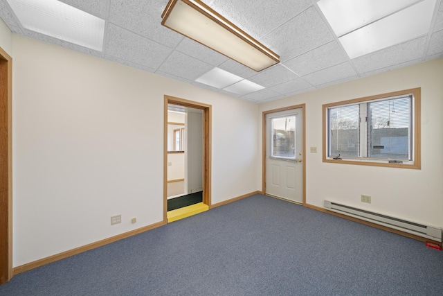 unfurnished room with a paneled ceiling, carpet floors, and a baseboard heating unit