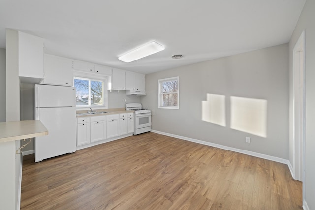 kitchen with sink, white cabinets, white appliances, and light hardwood / wood-style flooring