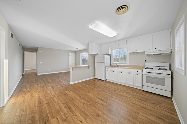 kitchen with sink, white cabinets, decorative backsplash, white appliances, and light wood-type flooring