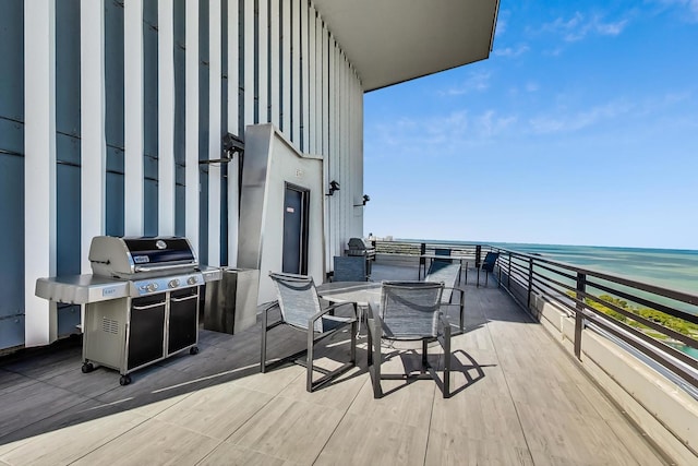 deck with a water view and area for grilling