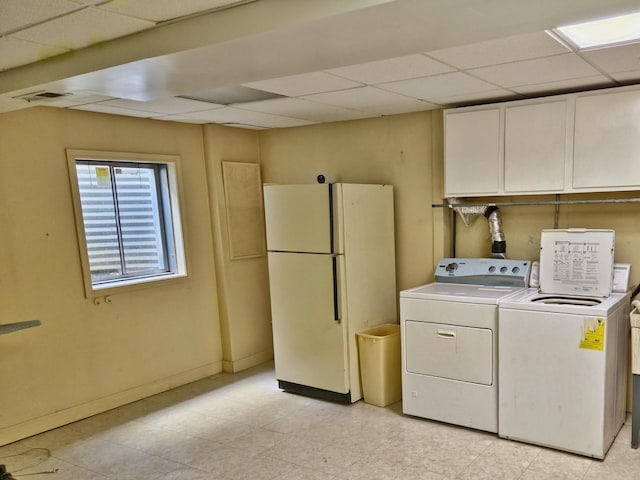 washroom featuring visible vents, baseboards, washing machine and dryer, light floors, and cabinet space