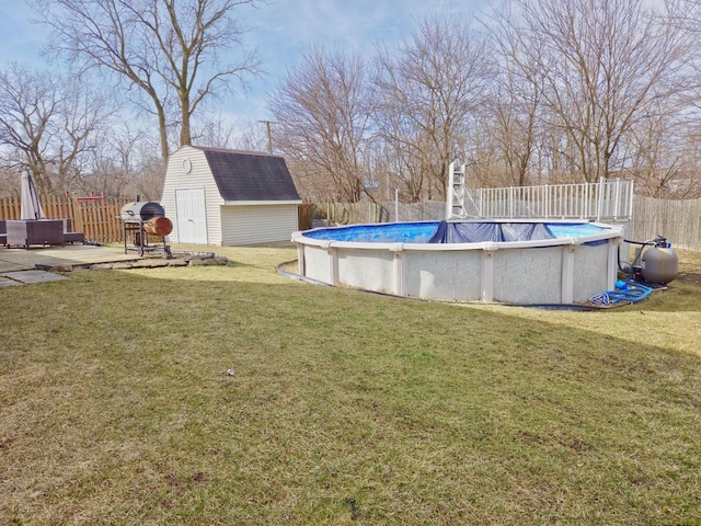 outdoor pool featuring a storage unit, an outbuilding, a yard, and fence