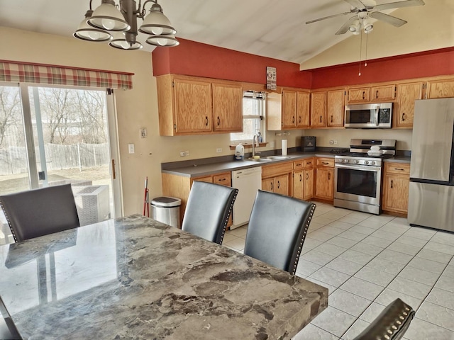 kitchen with light tile patterned flooring, decorative light fixtures, lofted ceiling, sink, and stainless steel appliances