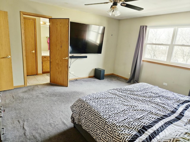 bedroom with ceiling fan, ensuite bath, and light carpet