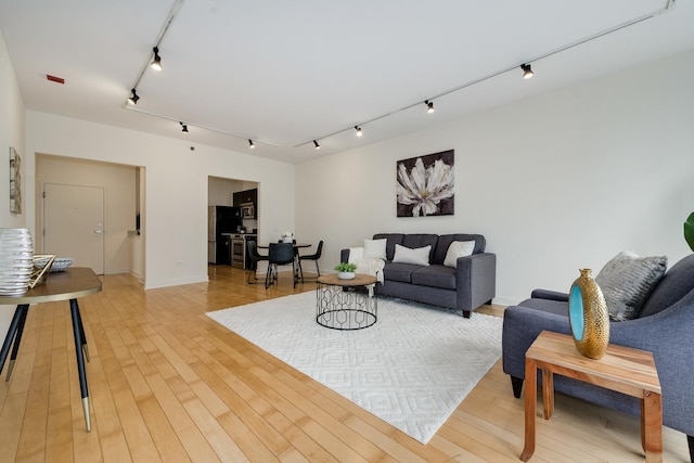 living room with track lighting and light hardwood / wood-style flooring