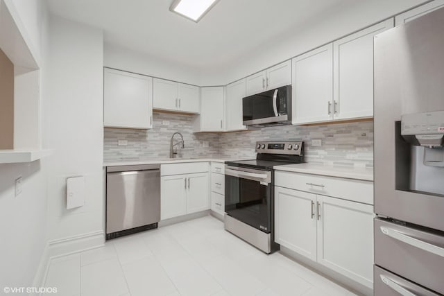 kitchen with appliances with stainless steel finishes, sink, white cabinets, and decorative backsplash