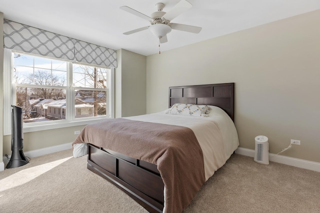 bedroom featuring light colored carpet, ceiling fan, and baseboards