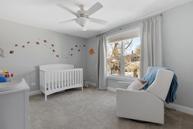 bedroom with a nursery area, light carpet, and baseboards