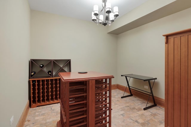 wine cellar with an inviting chandelier and baseboards