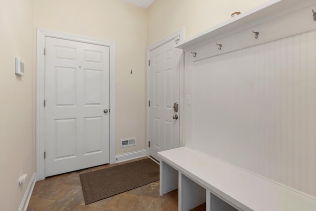 mudroom featuring stone finish floor, visible vents, and baseboards