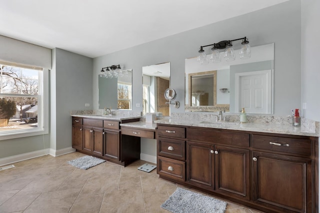 bathroom featuring tile patterned flooring, baseboards, a wealth of natural light, and vanity