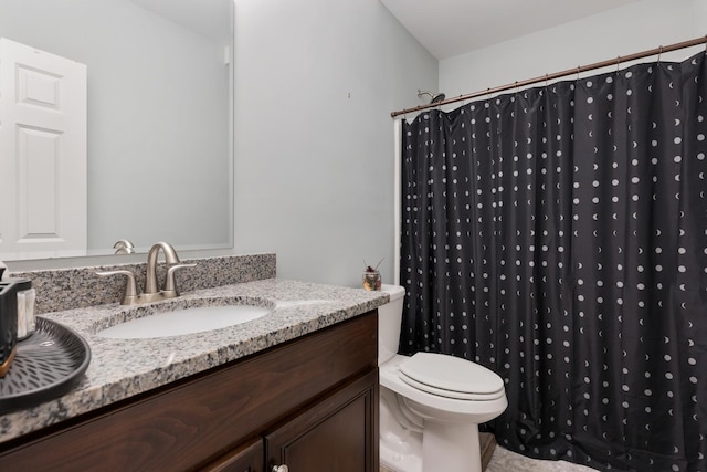 bathroom featuring curtained shower, vanity, and toilet