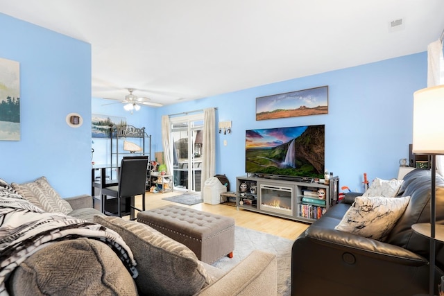 living room with ceiling fan and light wood-type flooring