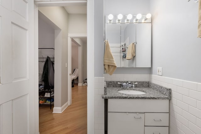 5331 S Harper Ave Unit 1, Chicago, IL 60615 - bathroom featuring wood finished floors, tile walls, and vanity