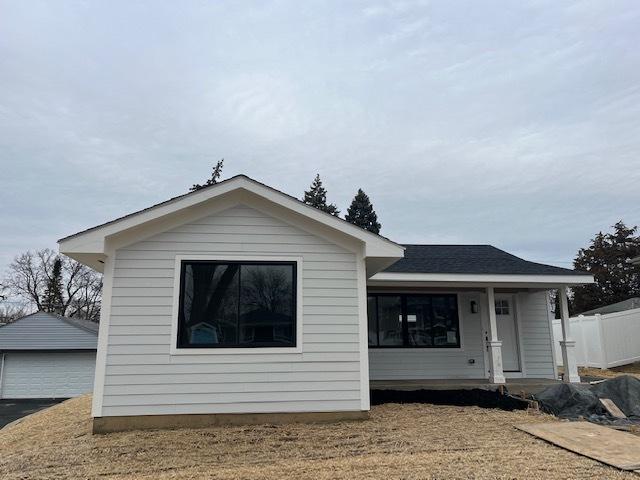 view of front of house with an outbuilding, a garage, and a front lawn