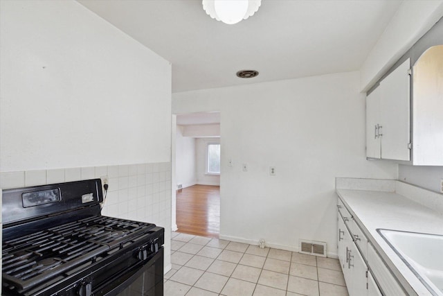 kitchen with white cabinetry, sink, gas stove, and light tile patterned floors