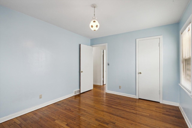 unfurnished bedroom with dark wood-type flooring