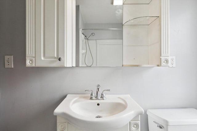 bathroom featuring vanity, toilet, and walk in shower