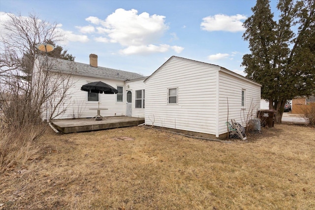 back of property featuring a yard and a deck