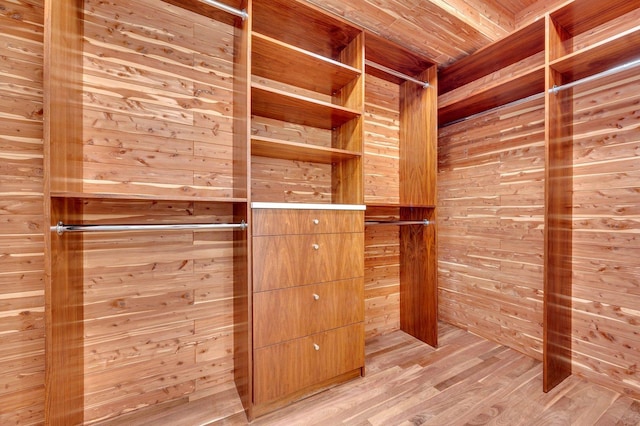 walk in closet with light hardwood / wood-style flooring