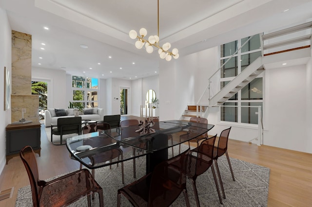 dining room with light hardwood / wood-style flooring and a chandelier