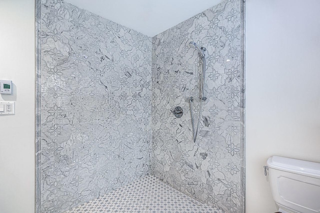 bathroom featuring toilet and tiled shower