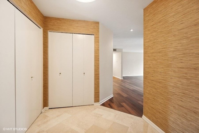 hallway with wood finished floors and baseboards