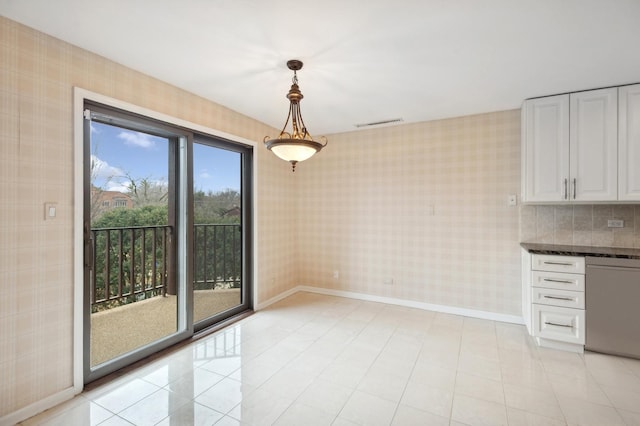 unfurnished dining area featuring light tile patterned flooring, visible vents, wallpapered walls, and baseboards