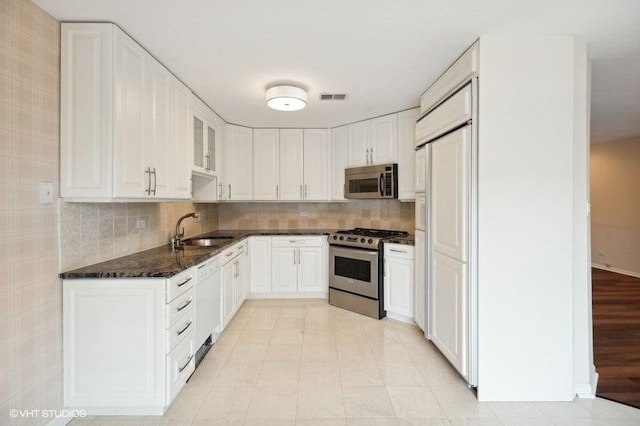 kitchen featuring tasteful backsplash, visible vents, stainless steel appliances, and a sink