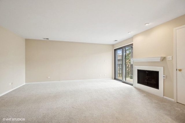 unfurnished living room with visible vents, a fireplace, baseboards, and carpet