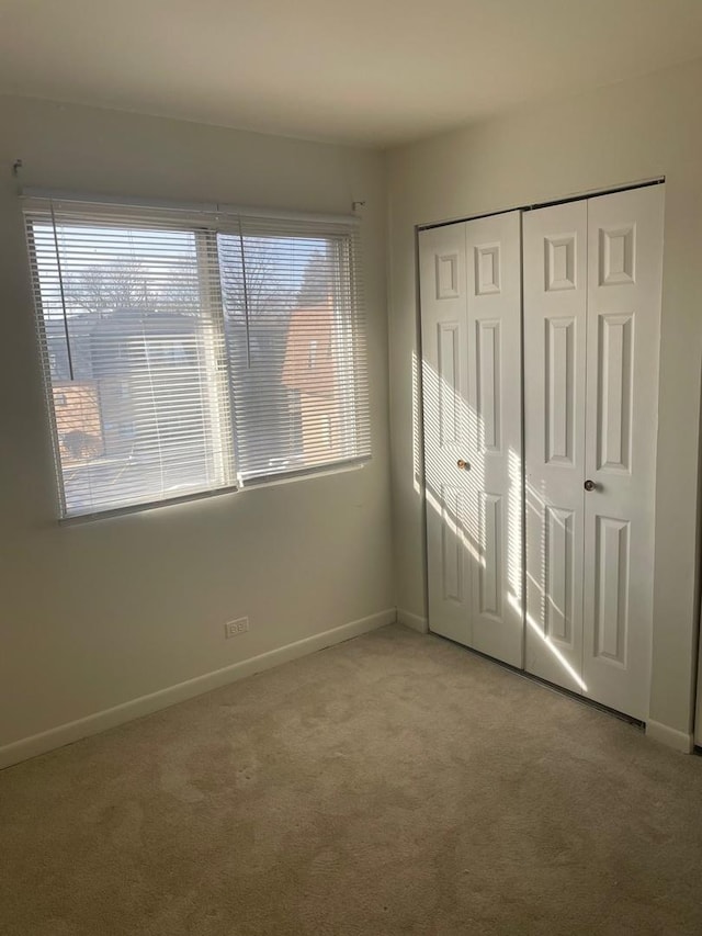 unfurnished bedroom with multiple windows, a closet, and carpet