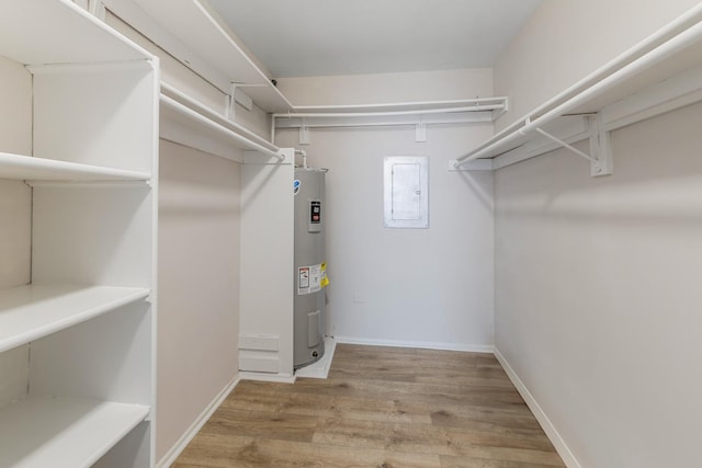 spacious closet featuring water heater, wood-type flooring, and electric panel