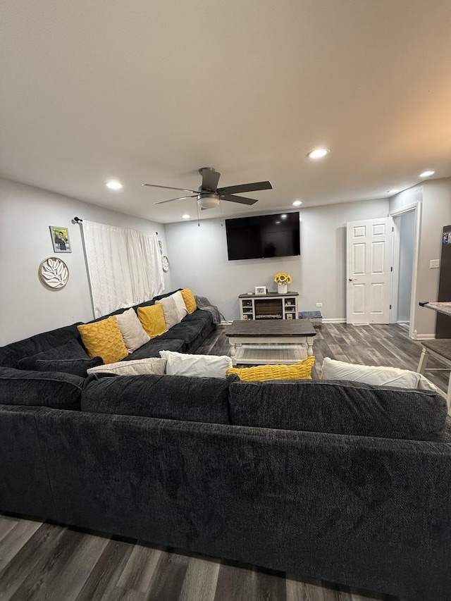 living room featuring wood-type flooring and ceiling fan