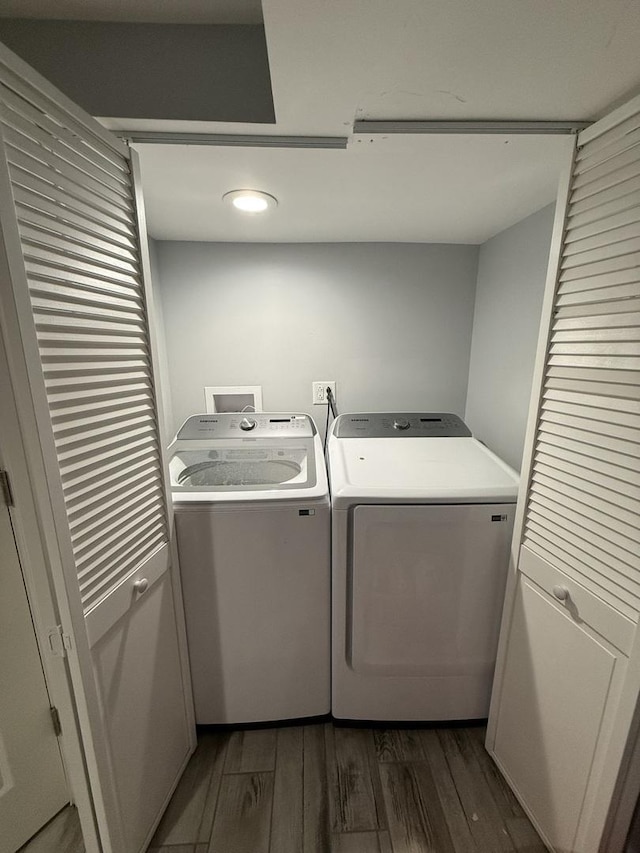 clothes washing area featuring washer and dryer and dark wood-type flooring