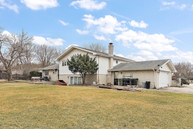 rear view of property featuring a garage and a yard