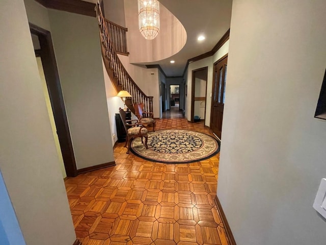 hallway with crown molding, light parquet floors, and a chandelier