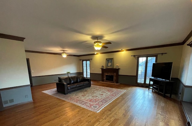 living room featuring hardwood / wood-style flooring, ornamental molding, and ceiling fan